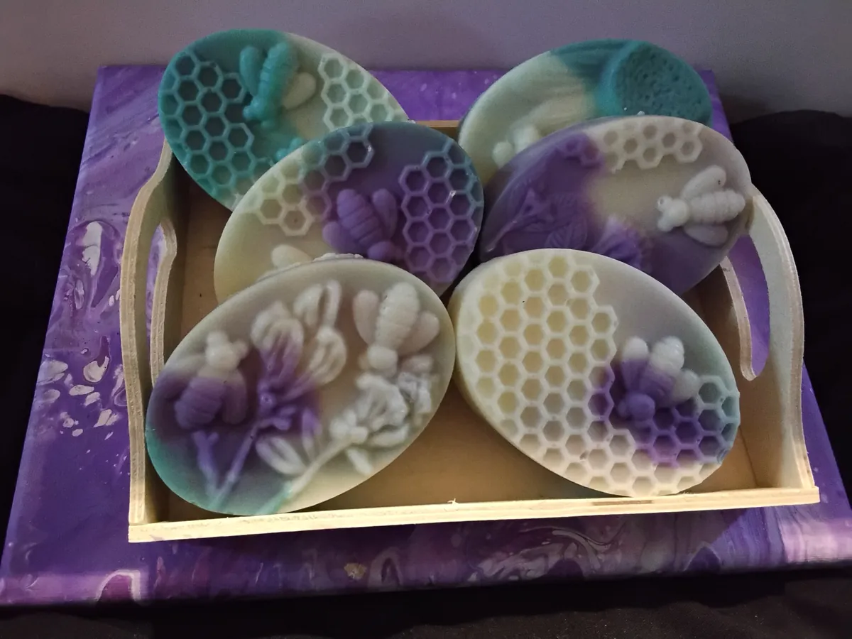 Oval honeycomb soaps with bees and flowers in purple and teal